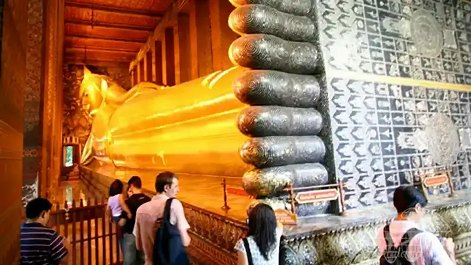 Wat Pho in Bangkok Visitors viewing the golden Reclining Buddha statue inside Wat Pho temple in Bangkok"